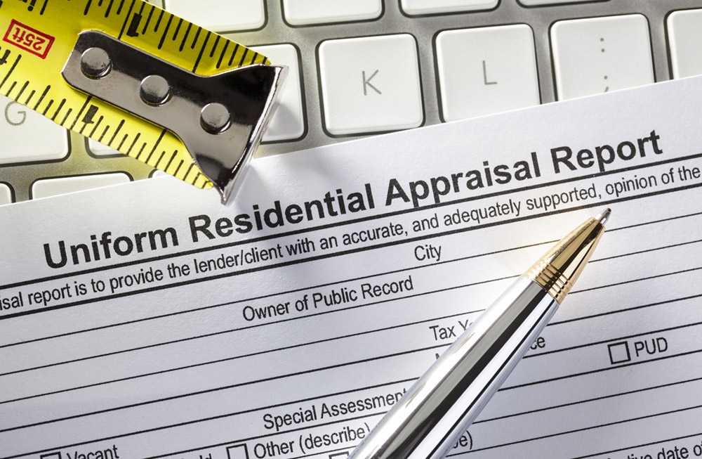 Measuring tape and pen on top top of appraisal form, on top of keyboard